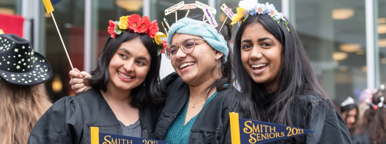 Three students in Rally Day hats, smiling.