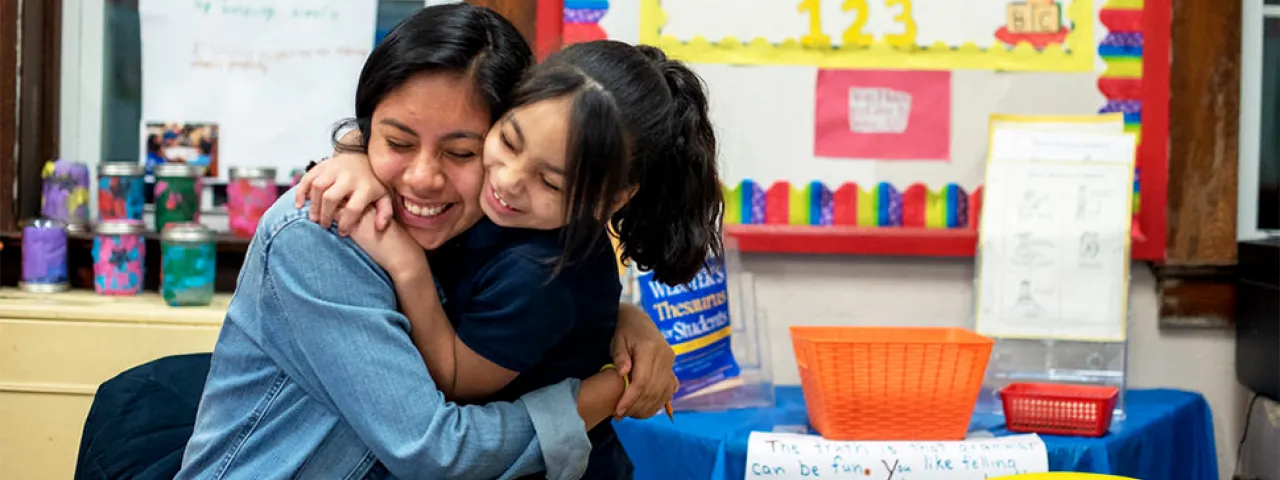 Smith student doing community service and hugging a child in school