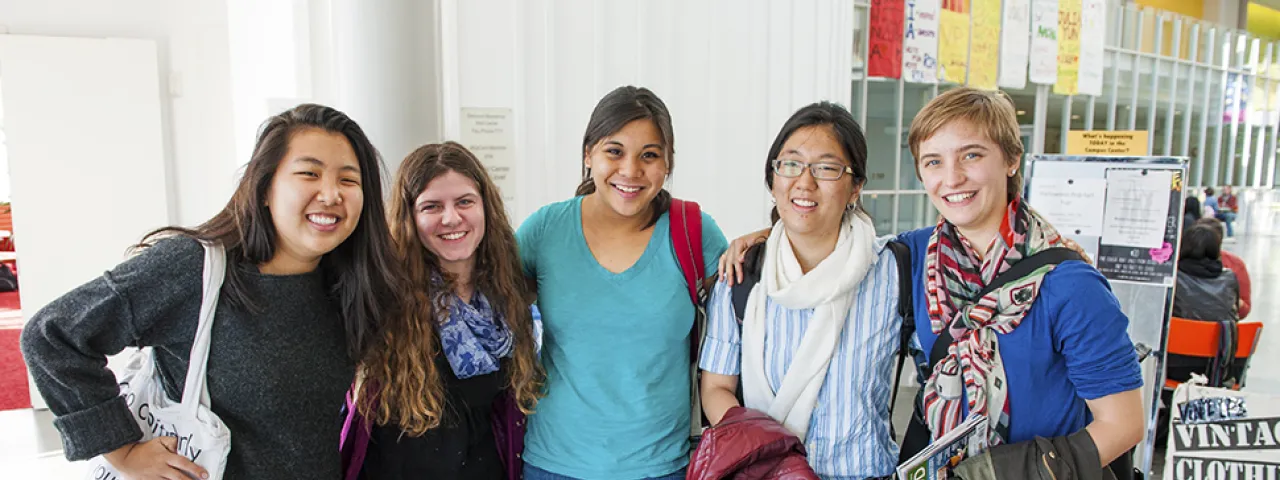 A group of smiling students posing in the Campus Center