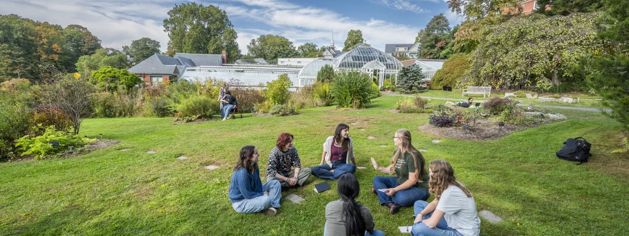 group of students sitting in the grass in front of Lyman