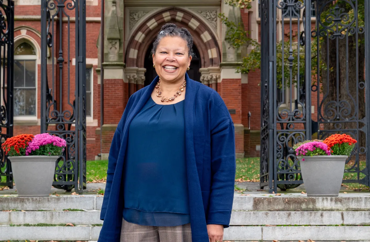 Sarah Willie-LeBreton smiling and standing outside of College Hall. 