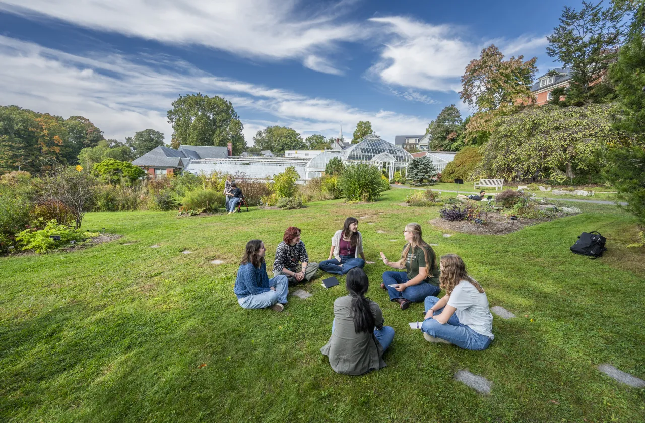 group of students sitting in the grass in front of Lyman