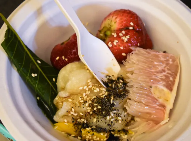 Mochi bowl with pomelo slice and whole strawberry.