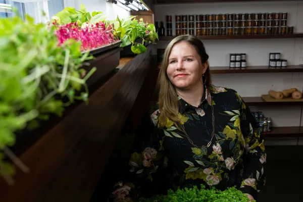 Jessie Banhazl next to hydroponic vegetables