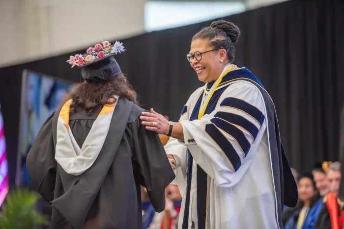 President Sarah Willie-LeBreton with a student at Commencement