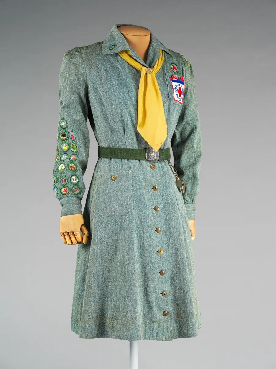 Green long-sleeved, button-up dress with a yellow tie under the color.