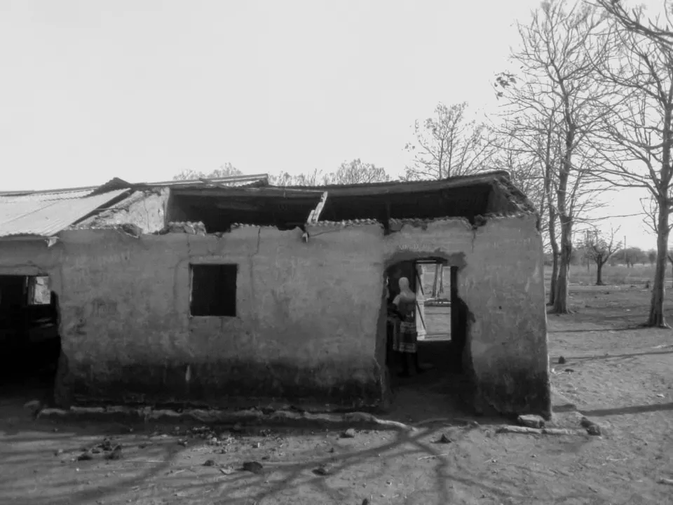 A building with a large section of missing roof and crumbling walls.