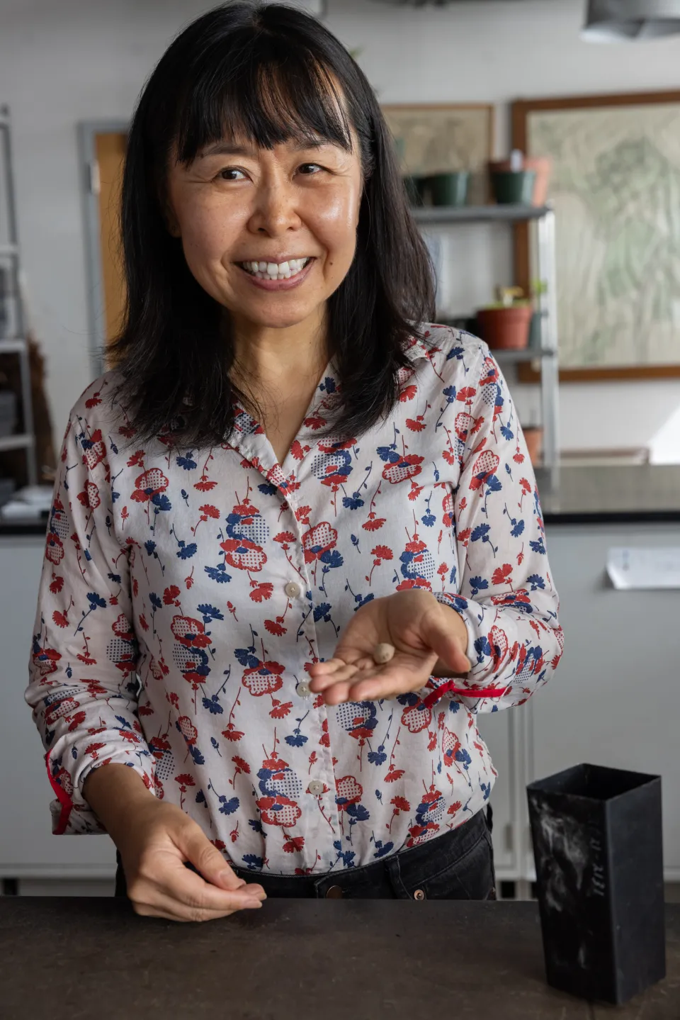 Professor Atsuko Takahashi holds a tan gingko seed