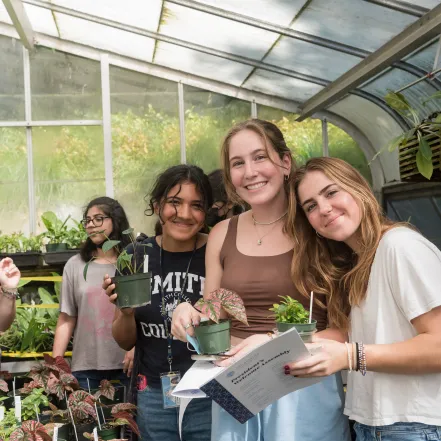 A group of students pick out their first-year plants in the greenhouse.