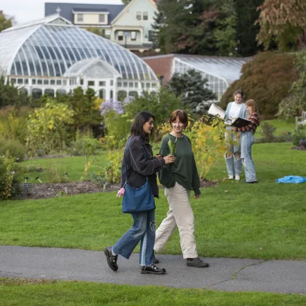 Two students walking in front of Lyman Conservatory.