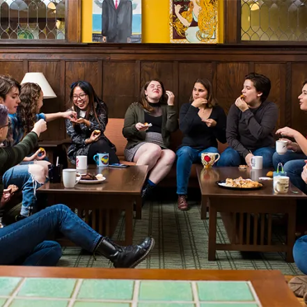 Group of students having tea in a house living room