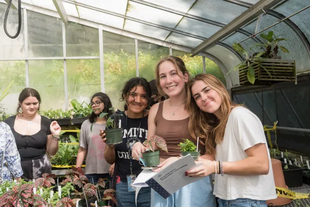 A group of students pick out their first-year plants in the greenhouse.
