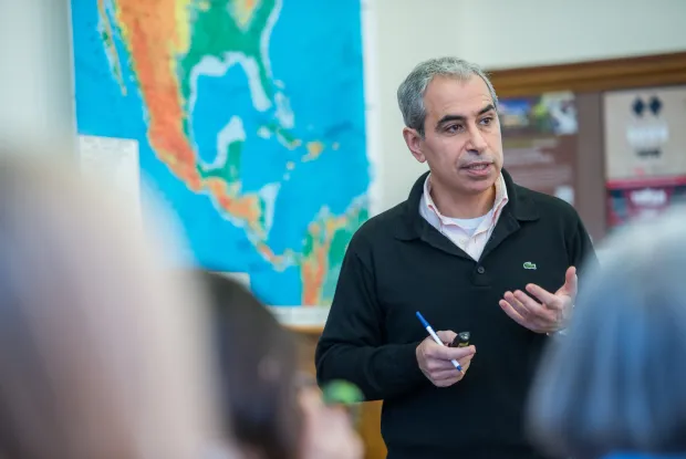 A professor teaching in front of a map.