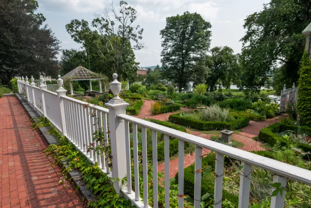 White railing that leads to the Happy Chace 1928 Garden.