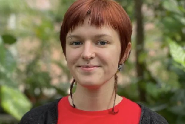 Girl with short red hair wearing red shirt.